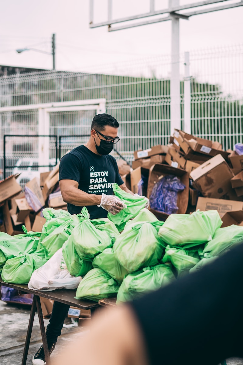 a man in a black shirt and some bags handing out goods confidently because they have nonprofit insurance